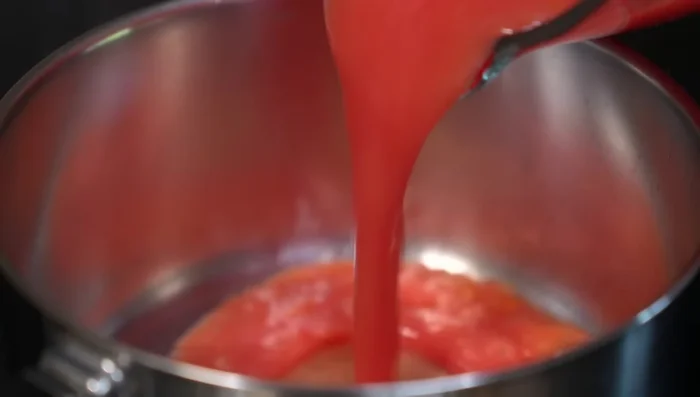In a saucepan, sauté the blended tomato mixture with oil. Season with salt, chicken broth powder, pepper, and oregano. Add tomato puree and simmer until flavors meld.