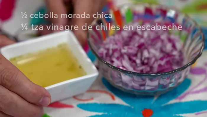 Chop red onion, add pickled chili vinegar, and let it sit for 10 minutes to reduce strong flavor. Drain.