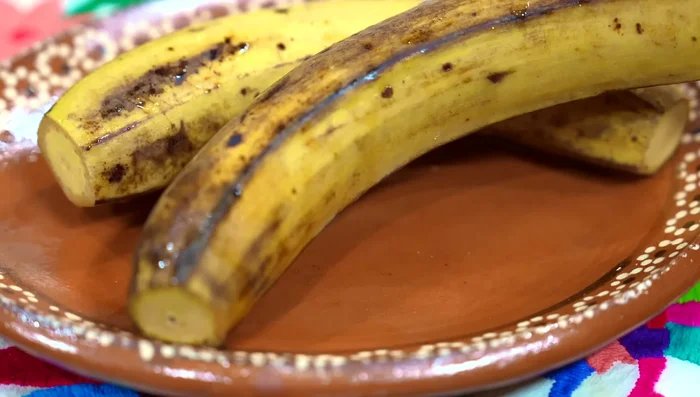 Wash plantains thoroughly, remove tips, and cut in half.