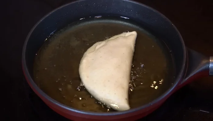 Fry the empanadas: Carefully fry the empanadas in hot oil until golden brown on both sides. Remove and drain on a rack.