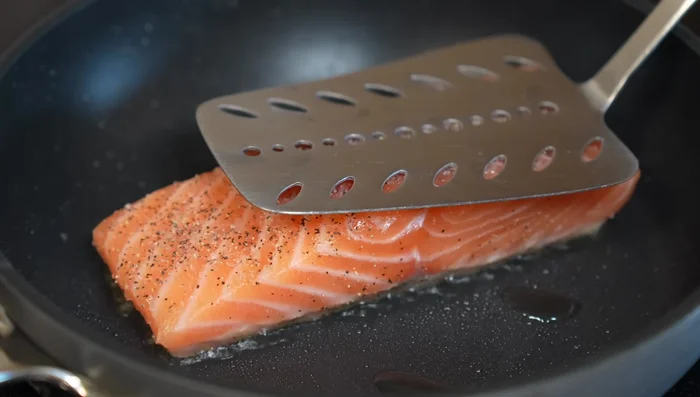Gently press the fish with a spatula for a few seconds to prevent sticking and ensure even cooking.
