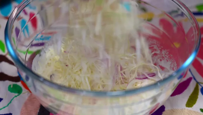 Add the cabbage and red onion to the dressing and mix well. Let it rest.