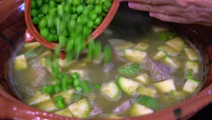 Add the epazote, peas, and green beans. Simmer on medium-low heat for 15 minutes to allow flavors to meld.