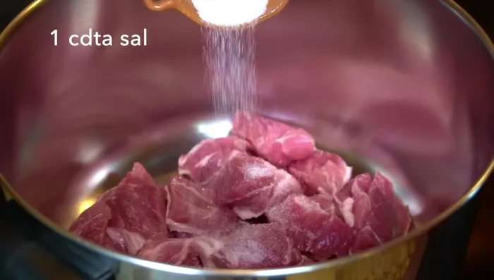 In a pot, combine the pork, salt, garlic, onion, and water. Bring to a boil, then reduce heat to medium, cover, and simmer until the pork is tender (about 1 hour or 25 minutes in a pressure cooker).