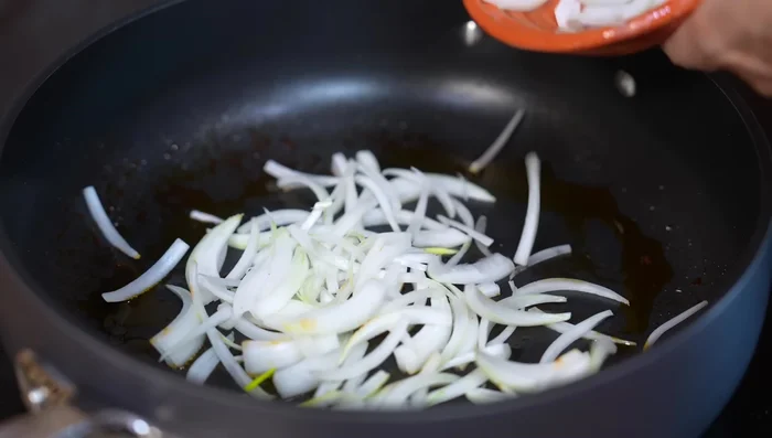 In the same pan, sauté the onions and potatoes in the chorizo fat until slightly softened. Add salt.