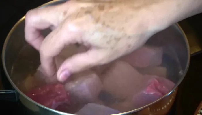 Add beef to boiling water with half an onion, three cloves of garlic, thyme, marjoram, bay leaves, and salt. Cover and cook over medium heat for about 2 hours, or until tender.