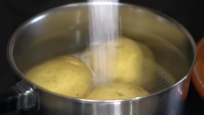 Boil potatoes with their peel intact in salted water until tender (35-40 minutes). Avoid opening the pot to prevent water absorption.