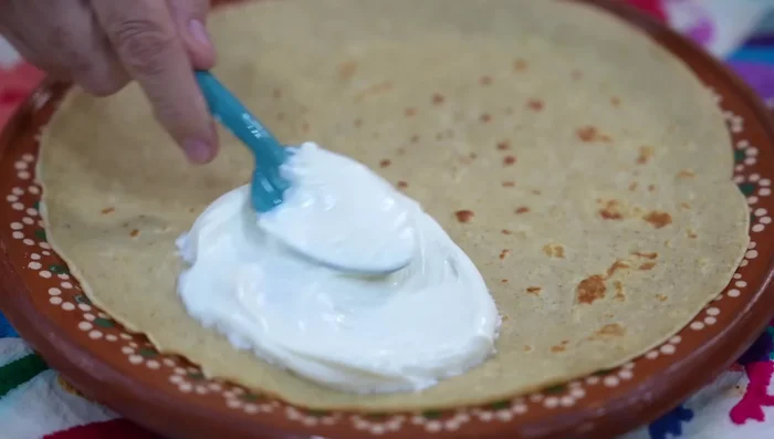 Spread cream cheese filling onto a quarter of each crepe. Add jam, fruit, and fold the crepe in half.