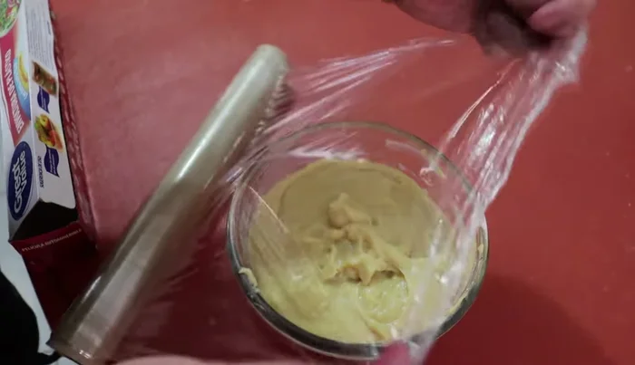 Pour the pastry cream onto a surface covered with non-stick plastic wrap, pressing it down to ensure contact with the plastic to prevent a skin from forming.