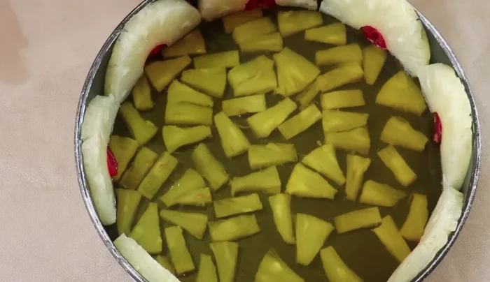 Pour the three-milk mixture over the layered fruit. Gently tap the mold to remove air bubbles.