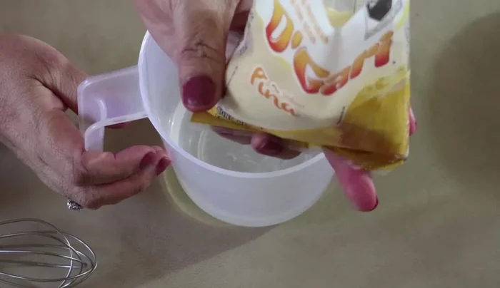 Prepare the pineapple gelatin: Dissolve one 120g envelope of pineapple-flavored gelatin in 1 liter of water (3 cups total, 1 cup boiling water, 2 cups cold water). Let it sit for 10 minutes.