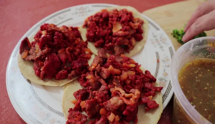 Serve the steak and chorizo mixture in warm tortillas. Garnish with chopped cilantro, a squeeze of lemon, and green salsa.