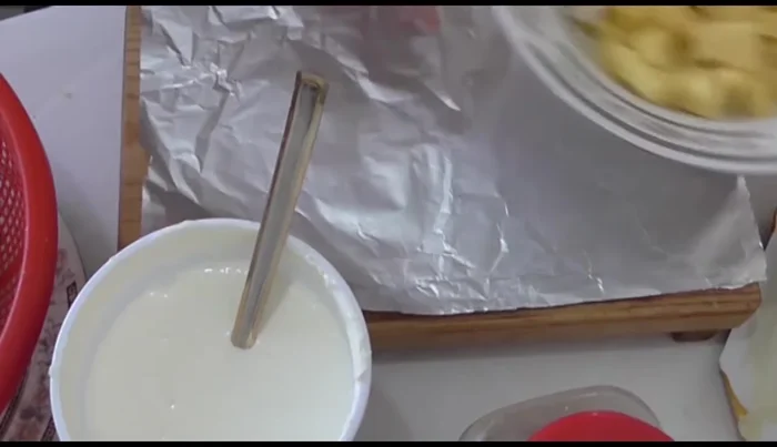 Assemble the potato soufflés: Cut potatoes into quarters, place on aluminum foil. Add butter, cream, Philadelphia cheese, Manchego cheese, ham, and a pinch of salt to each potato quarter.