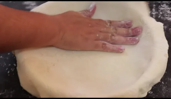 Line the mold: Place the rolled-out pastry into the baking mold, pressing it into the bottom and sides (412.199). Trim any excess pastry. Use a fork to prick the bottom and sides of the pastry to prevent it from puffing up too much (439.8).