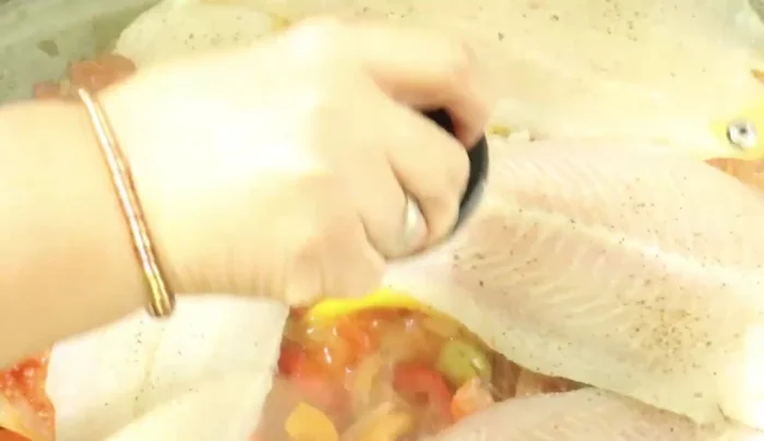 Cover and cook for about 5 minutes, then flip the fish and cook for another 5 minutes, ensuring the fish cooks evenly and absorbs the flavors.