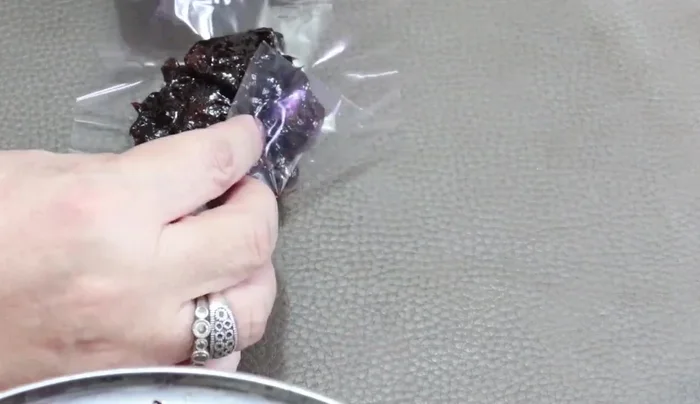 Fill and wrap the candy: Place a small amount of the cooled tamarind mixture (with or without chili) onto a cellophane square. Fold the corners to create a candy shape and wrap securely.