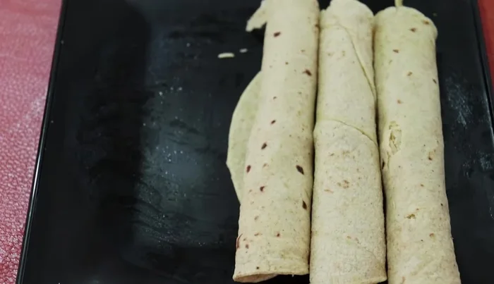 Fill each tortilla with shredded chicken.