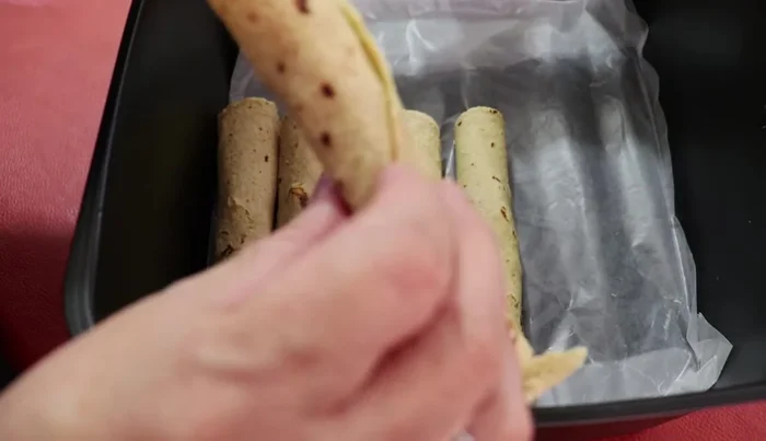 Arrange the taquitos in the air fryer basket.