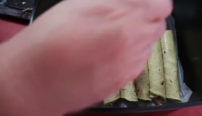 Lightly brush the taquitos with cooking oil.