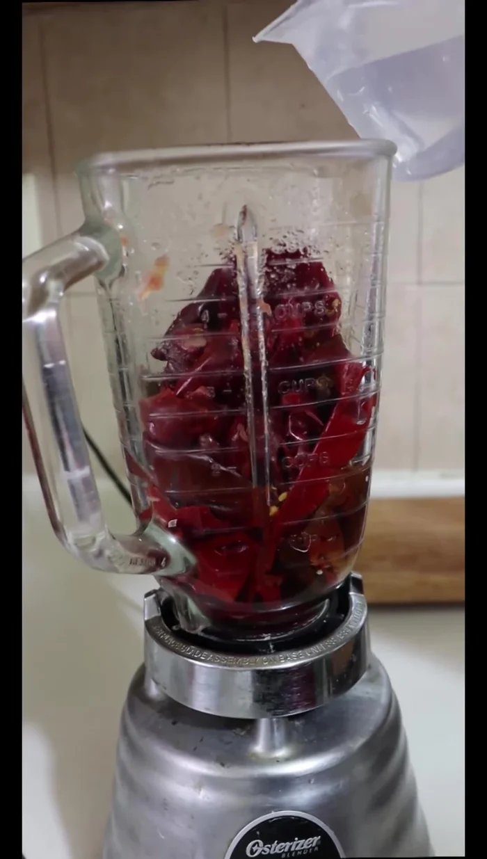 In a separate blender, blend the hydrated guajillo chiles with a cup of water. Strain.
