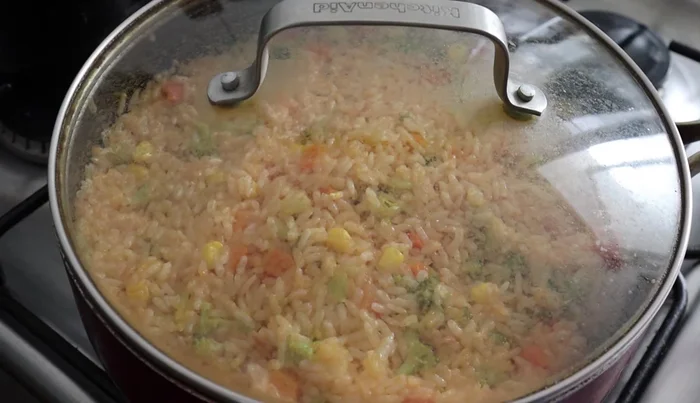 Turn off the heat and let the rice sit, covered, for another 5-10 minutes to allow the remaining water to be absorbed and the rice to become fluffy.