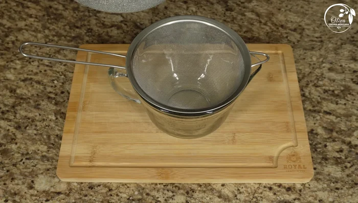Strain the consommé through a colander to remove solids.