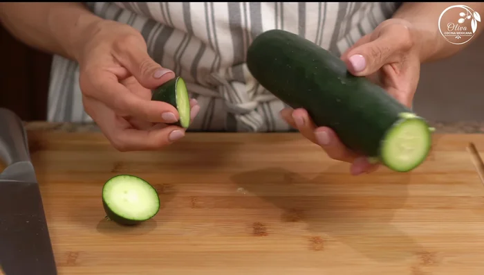 Prepare the cucumbers: Remove ends, rub to remove bitterness, peel partially, halve, and cut into cubes.