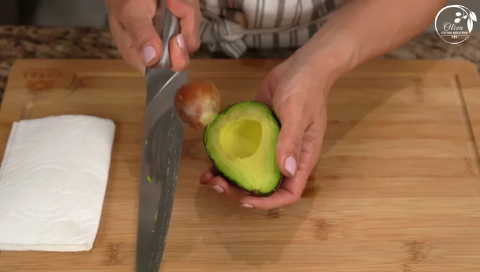 Cut avocado into cubes, add lemon juice to prevent browning, and gently fold into the salad.