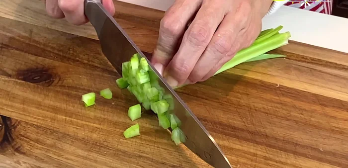 Finely chop the celery into squares. (140.8)