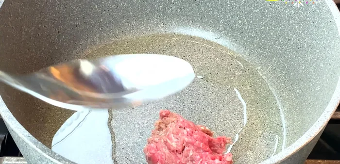 Heat olive oil in a pan over medium heat. Add ground beef and cook, breaking it up, until three-quarters cooked (parboiled). (193.61)