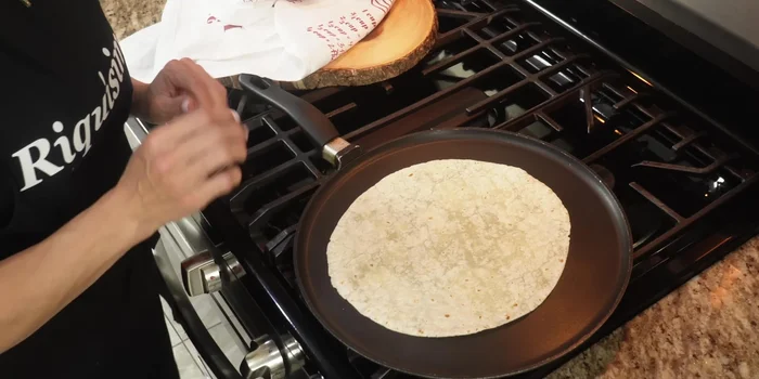 Heat the flour tortillas on a griddle to soften.