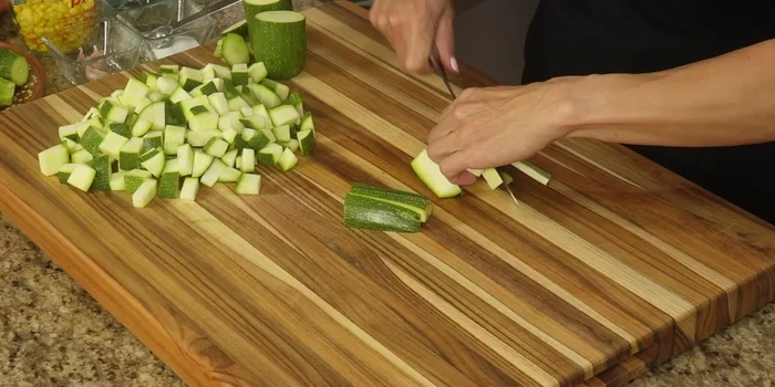 Cut the zucchini lengthwise into sticks, then into small squares. Reserve.