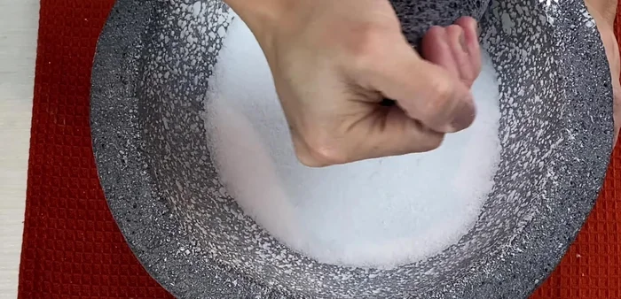 Add salt to the molcajete and grind gently using circular and straight movements to remove remaining dust.