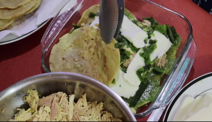 Repeat layers: tortillas, chicken, sauce, and cheese.