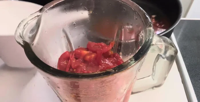 Blend tomatoes with other ingredients and minimal water. Blend very well. Add more water if needed.