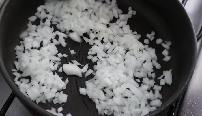 Add the shredded chicken to the pan and cook, stirring occasionally, until heated through and flavored with the onion. Season with salt and garlic to taste.