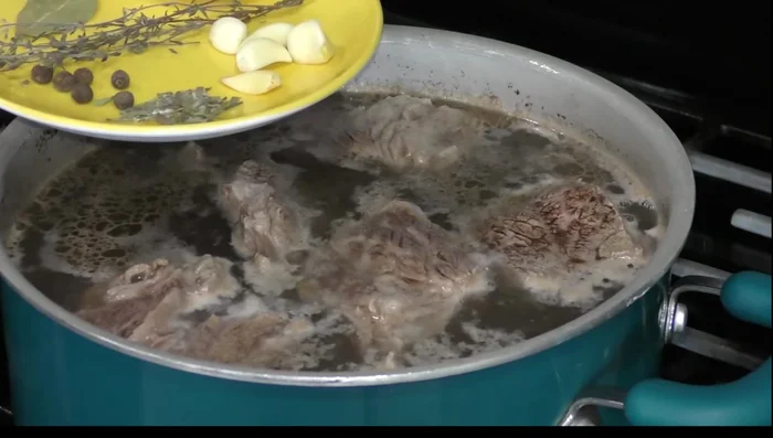 Remove foam and impurities from the boiling broth.