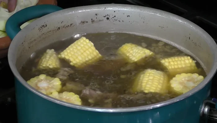 Add the carrots, chayote, and the blended chili sauce to the pot. Remove the peppers, onion, and thyme sprigs from the broth.