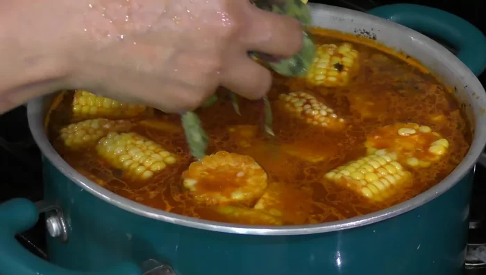 Rinse the epazote branches and add them to the pot along with a teaspoon of salt and two tablespoons of oil. Mix in the corn dough to form small balls.