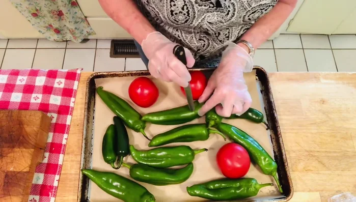 Preheat your oven to broil. Wash and stab the chilies and tomatoes 1-2 times to prevent them from exploding. Place them on a baking sheet lined with parchment paper or foil.