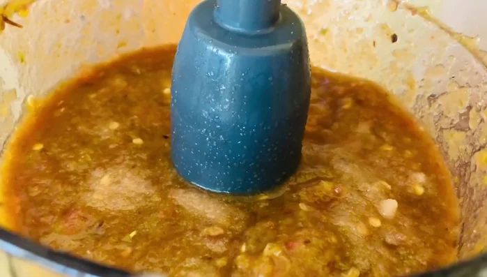 Add the juice from the roasted pork to the blended chili sauce. Add the pork chunks to the sauce.