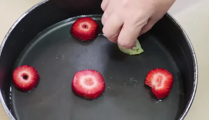 Arrange strawberries on the semi-set gelatin layer, add a little more clear gelatin to secure the fruit.