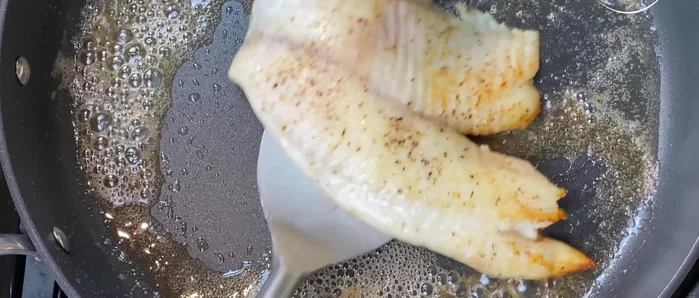 Transfer the partially cooked fish to a baking tray. Grease the bottom and sides of the tray with butter, add the fish, and arrange them.