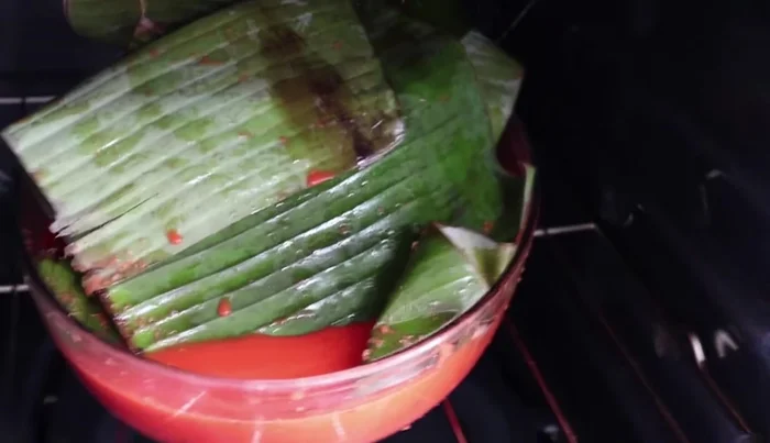 Bake the chicken: Preheat the oven to 200°C (approximately). Bake the chicken (covered with banana leaves and aluminum foil) for about 1-1.5 hours, basting every half hour with the marinade. Remove foil for the last 45 minutes to brown the chicken. (400.96, 437.479)