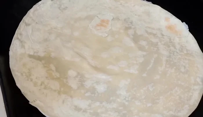 Heat a flour tortilla on a griddle until lightly toasted (315.4).