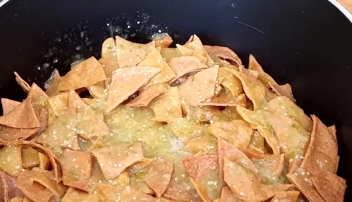 Pour the blended sauce over the tortilla pieces, turning to coat (522.519).