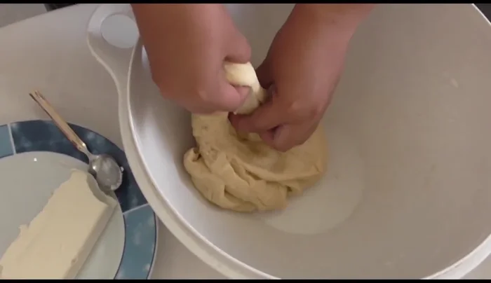 Punch down the dough and form small balls. Flatten each ball and add a small amount of cream cheese.