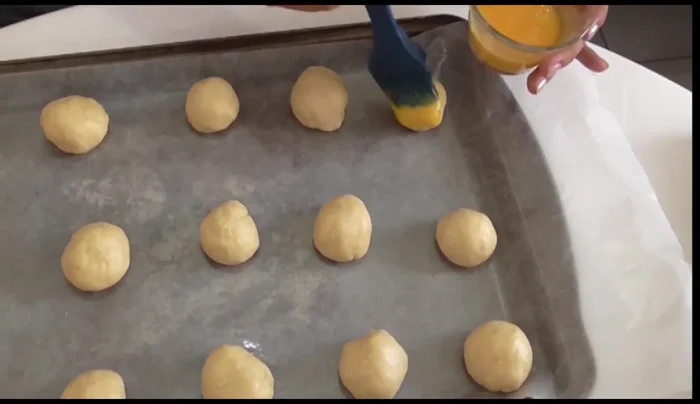 Beat an egg and brush it over the balls. Sprinkle with sesame seeds.