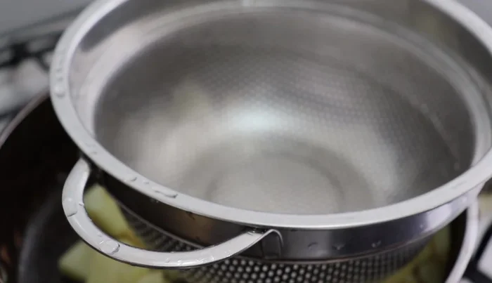 Strain the blended mixture into the saucepan with the potatoes.