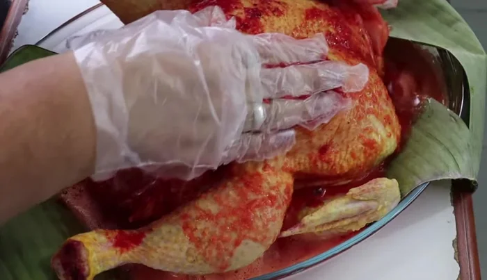 Spread the blended achiote mixture over the chicken, ensuring it gets between the skin and meat.